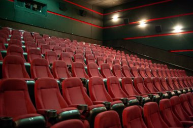 Kırmızı koltukları ve sandalyeleri olan boş sinema salonu.