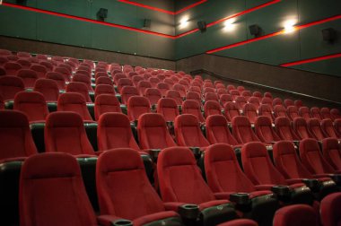 Kırmızı koltukları ve sandalyeleri olan boş sinema.