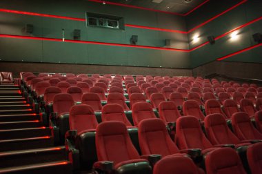 Kırmızı koltukları ve sandalyeleri olan boş sinema salonu.