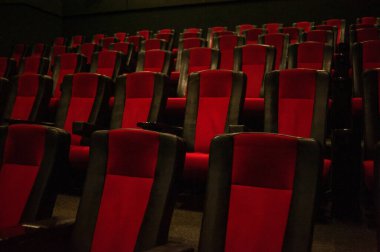 Kırmızı koltukları ve sandalyeleri olan boş sinema salonu.