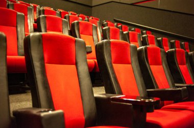 Kırmızı koltukları ve sandalyeleri olan boş sinema salonu.