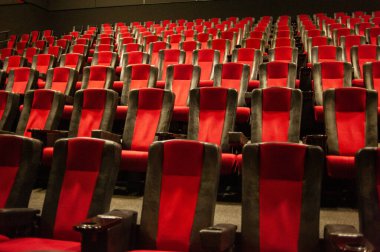 Kırmızı koltukları ve sandalyeleri olan boş sinema.