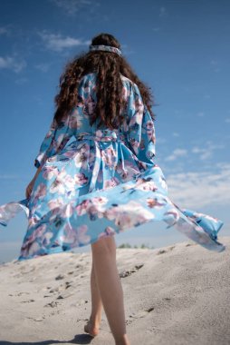 Plaj elbiseli güzel Asyalı kız denize poz veriyor.