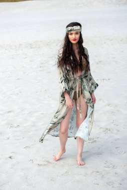 beautiful girl in a swimsuit and a white dress on the beach