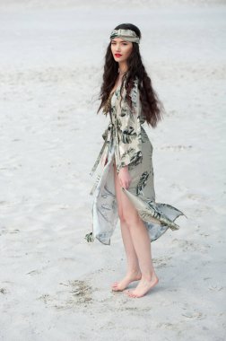 Sahilde beyaz elbiseli güzel bir kadın.