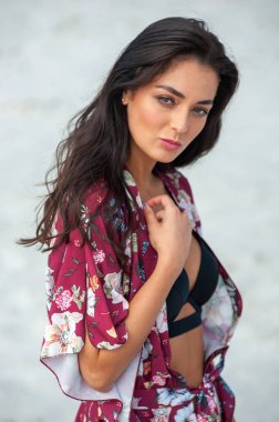 Kumsalda mayo giymiş güzel genç bir kadın.