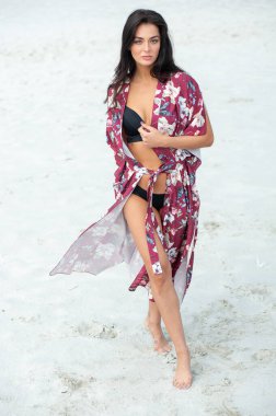 Kumsalda mayo giymiş güzel genç bir kadın.