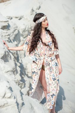 Beyaz elbiseli ve plajda şapkalı güzel bir kadın.
