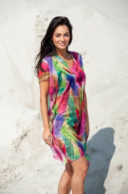 Kumsalda bikinili güzel bir kadın poz veriyor.