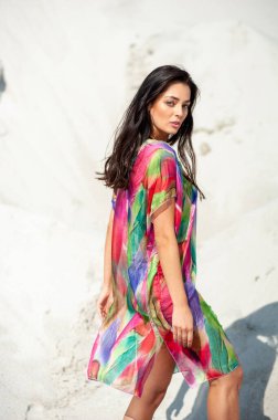 Kumsalda bikinili güzel bir kadın poz veriyor.