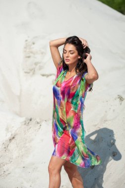 Plajda poz veren mayolu güzel genç bir kadın.