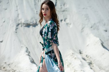 Plajda poz veren mayolu güzel genç bir kadın.