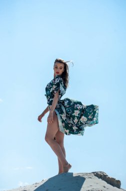 Plajda poz veren mayolu güzel genç bir kadın.