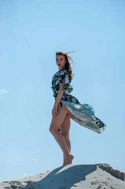 Sahilde poz veren güzel genç bir kadın.