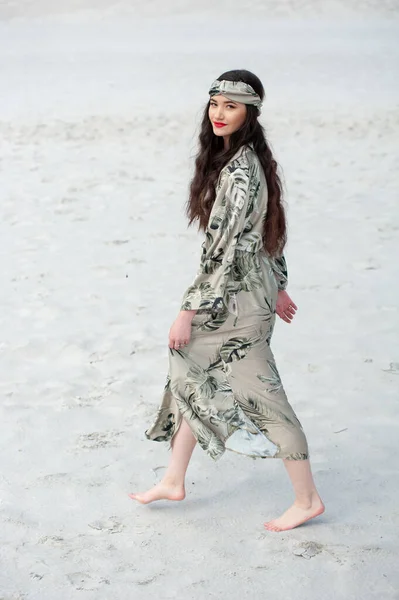 stock image beautiful young woman in a white dress and a hat on the beach