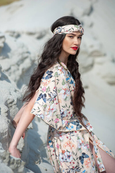 beautiful young woman in a white dress and a hat on the beach