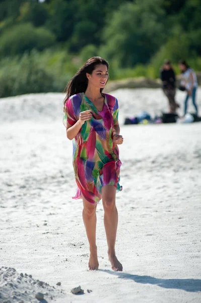 ビーチに袋を持ったドレスの若い女性が — ストック写真