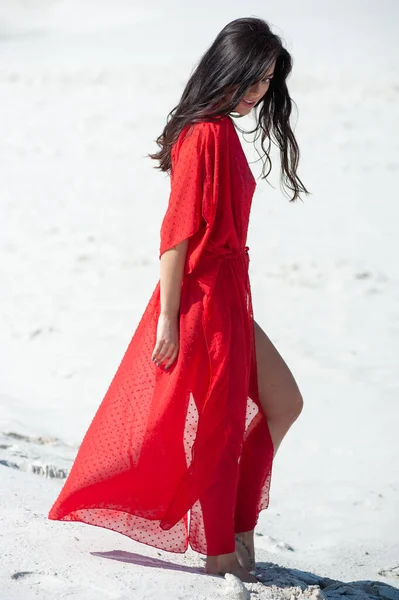 ビーチでポーズをとる赤いドレスを着た美しい若い女性 — ストック写真