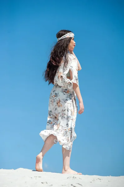 stock image beautiful young woman in white dress on the beach