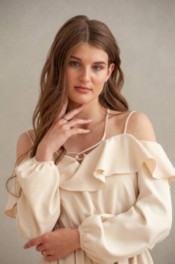 Beyaz elbiseli, uzun saçlı güzel bir genç kadının portresi.