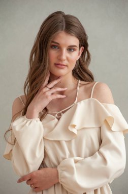 Beyaz elbiseli, uzun saçlı güzel bir genç kadının portresi.