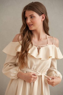 Beyaz elbiseli, uzun saçlı güzel bir genç kadın.