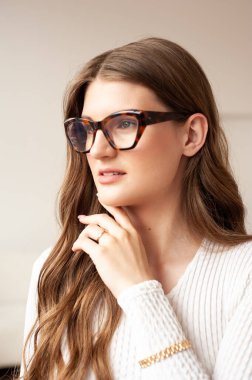 Beyaz gömlekli ve arka planda gözlüklü güzel bir genç kadının portresi.