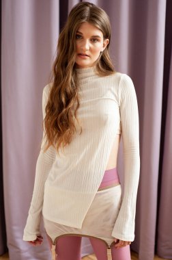 Stüdyoda rahat kıyafetlerle poz veren güzel bir kız. 