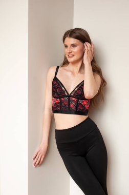 Pencerede iç çamaşırlı güzel bir kadın poz veriyor. 