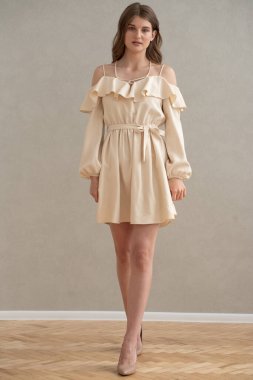 Güzel, genç, gülümseyen bir kadın portresi. Dalgalı saçlı. İç kısımda bej bir elbise giymiş. 