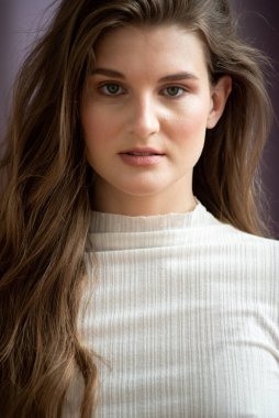 Genç, güzel, esmer bir mankenin yakın portresi. 