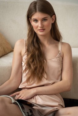 Odadaki kanepede oturan güzel genç bayan.