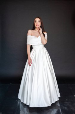 Gelinlik içinde güzel bir gelin stüdyoda poz veriyor, beyaz ve bej elbiseli genç bir kadının portresi 