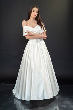 Gri arka planda gelinlik giymiş güzel esmer gelinin portresi. 