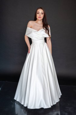 Uzun saçlı, beyaz gelinlikli güzel gelinin portresi. 