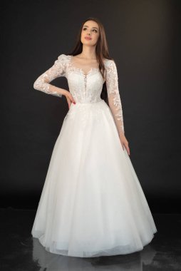 Gelinlik içindeki genç ve güzel gelin düğün töreni için poz veriyor. 