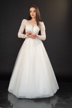 Gri arka planda poz veren güzel genç gelin. 