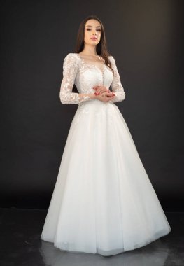 Beyaz elbiseli güzel gelin stüdyoda poz veriyor. 