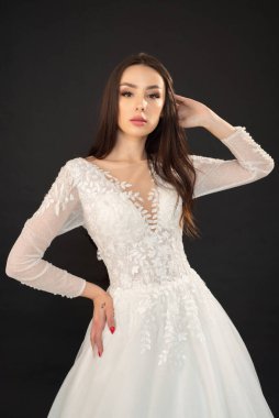 Stüdyoda gelinlik içinde genç ve güzel bir kadın. 