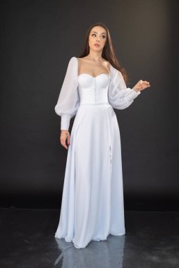 Stüdyoda beyaz gelinlik içinde genç güzel bir kız. 