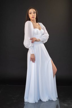 Stüdyoda beyaz elbiseli güzel bir esmerin portresi. 