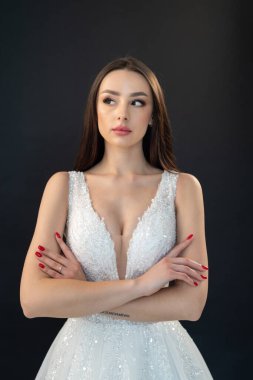 Beyaz arka planda zarif makyajı ve moda elbisesi olan güzel bir genç kadının portresi. 