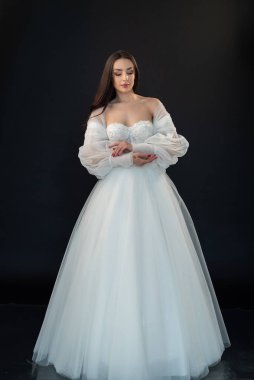  gelin siyah arka planda gelinlik pozu veriyor 