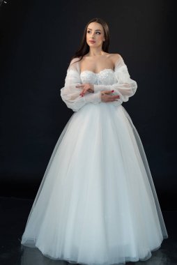  gelin siyah arka planda gelinlik pozu veriyor 