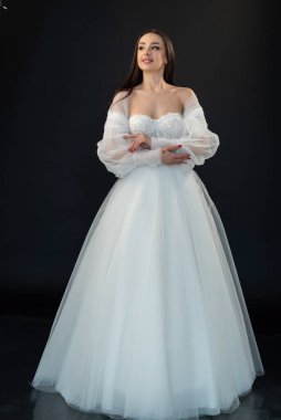  gelin siyah arka planda gelinlik pozu veriyor 