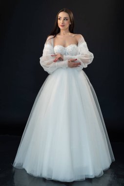  gelin siyah arka planda gelinlik pozu veriyor 