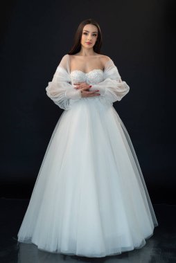  gelin siyah arka planda gelinlik pozu veriyor 