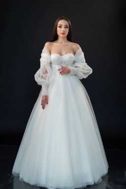  gelin siyah arka planda gelinlik pozu veriyor 