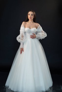  gelin siyah arka planda gelinlik pozu veriyor 