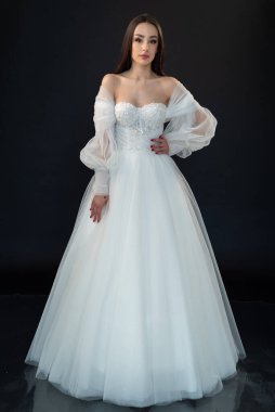  gelin siyah arka planda gelinlik pozu veriyor 